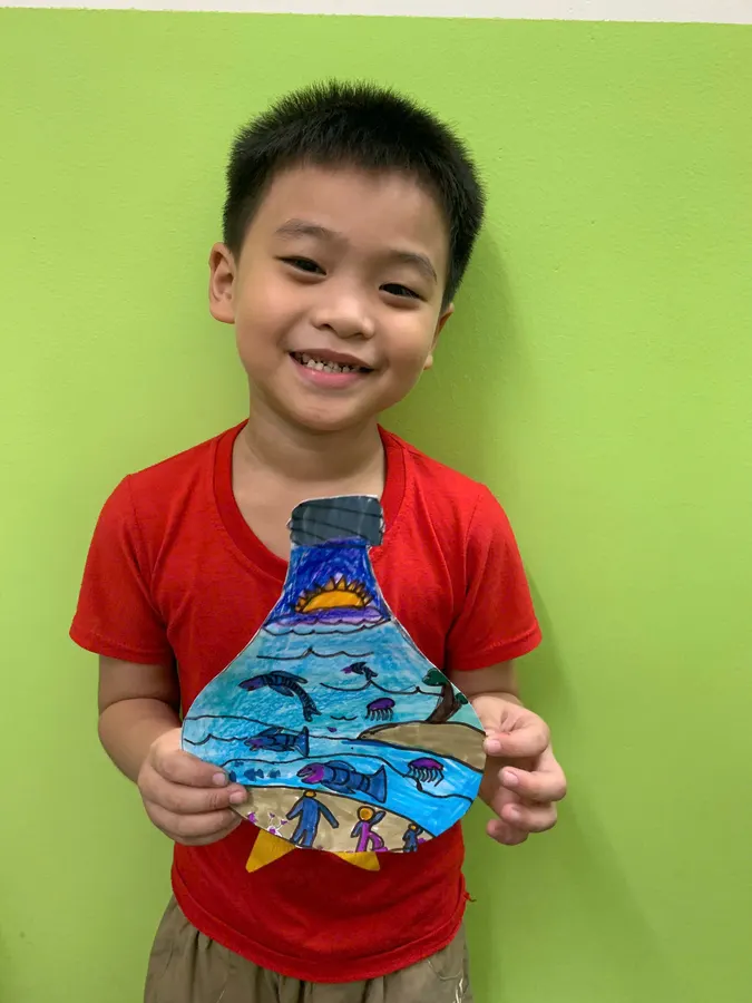 Student proudly showing his finished artwork