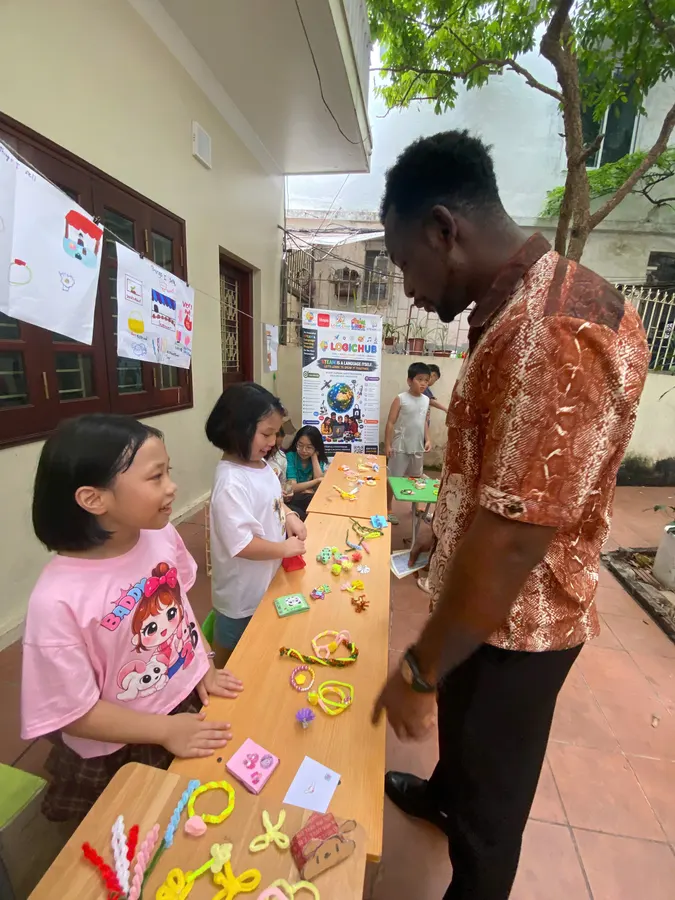 Student presenting her craft stall to a teacher at the HEC English fair