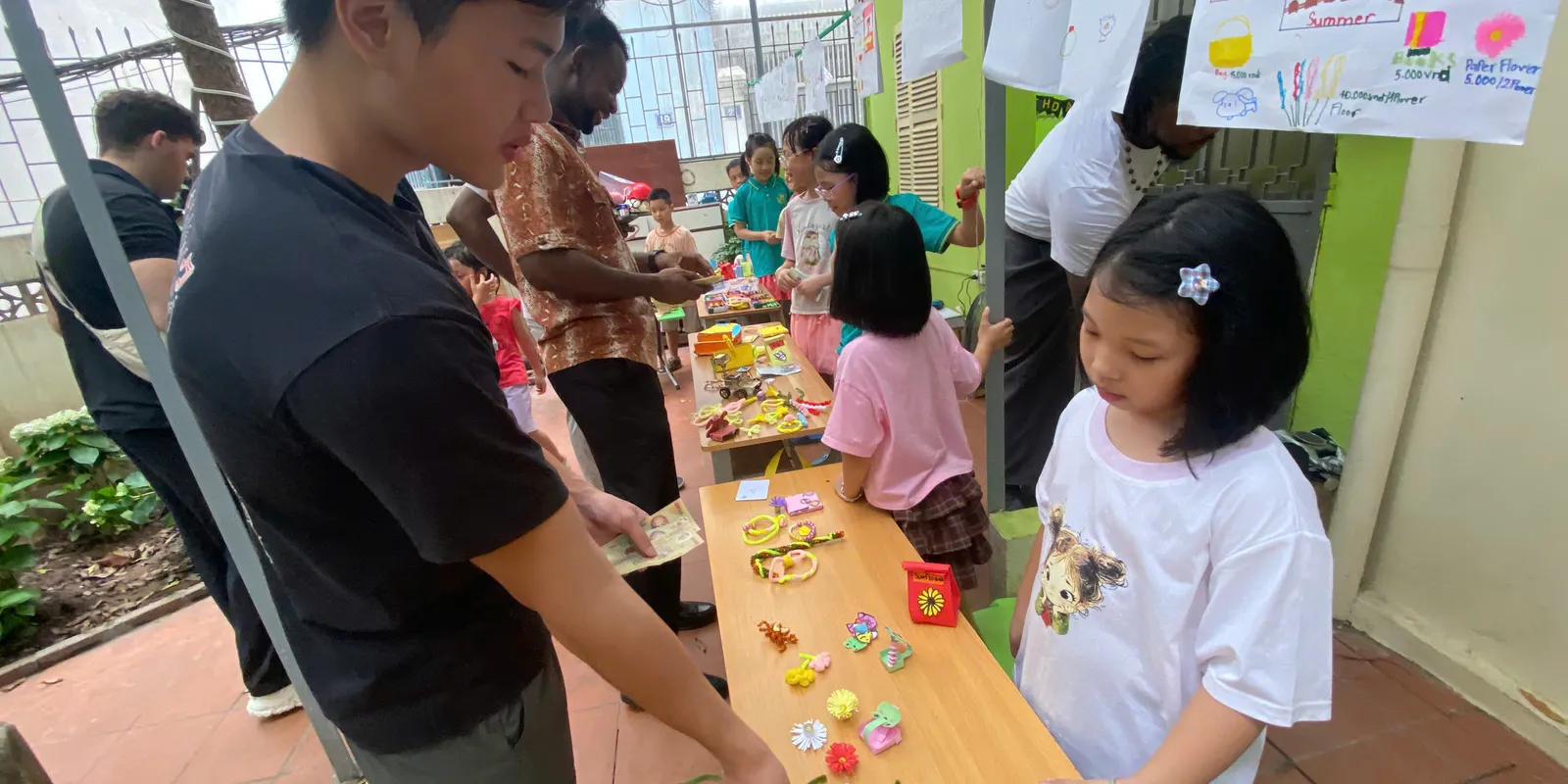 Students presenting crafts at the HEC English fair